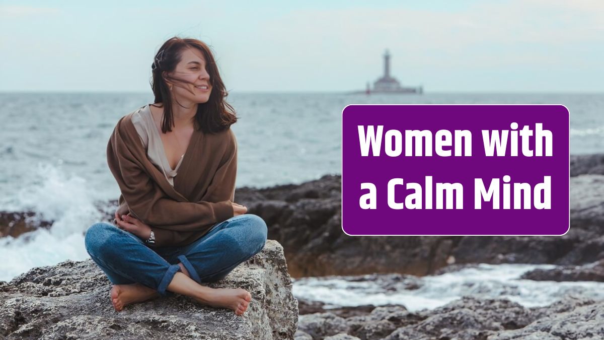 Woman sitting by rocky sea beach in wet jeans lighthouse on background.